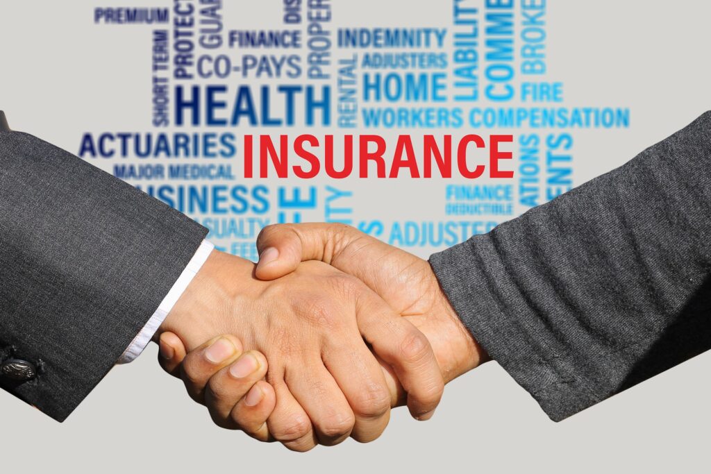 client and insurance broker shaking hands with a background image of insurance terms
