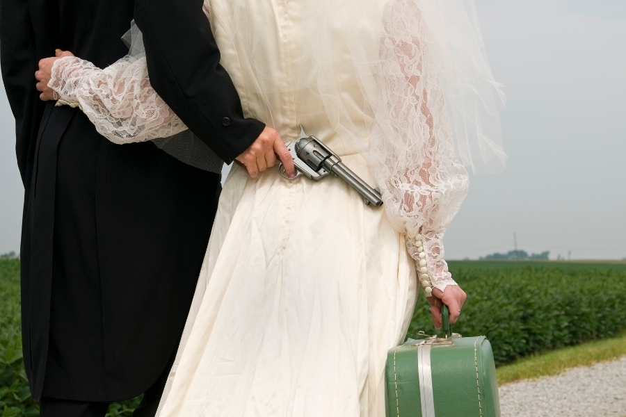 Man holding a gun behind his bride